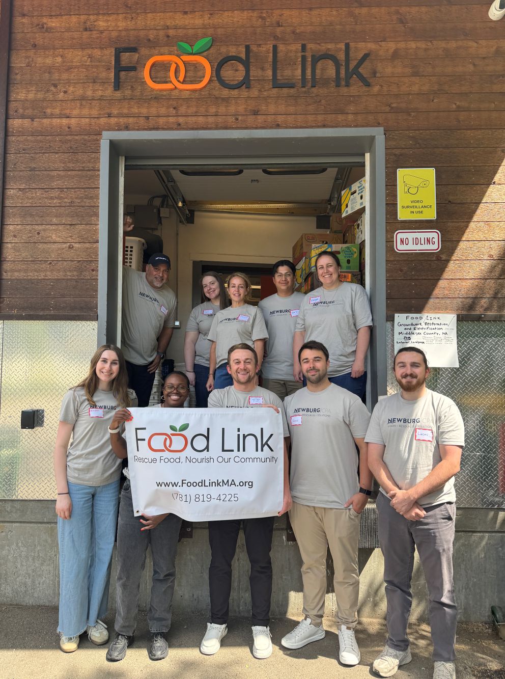 Volunteers holding a Food Link charity banner together