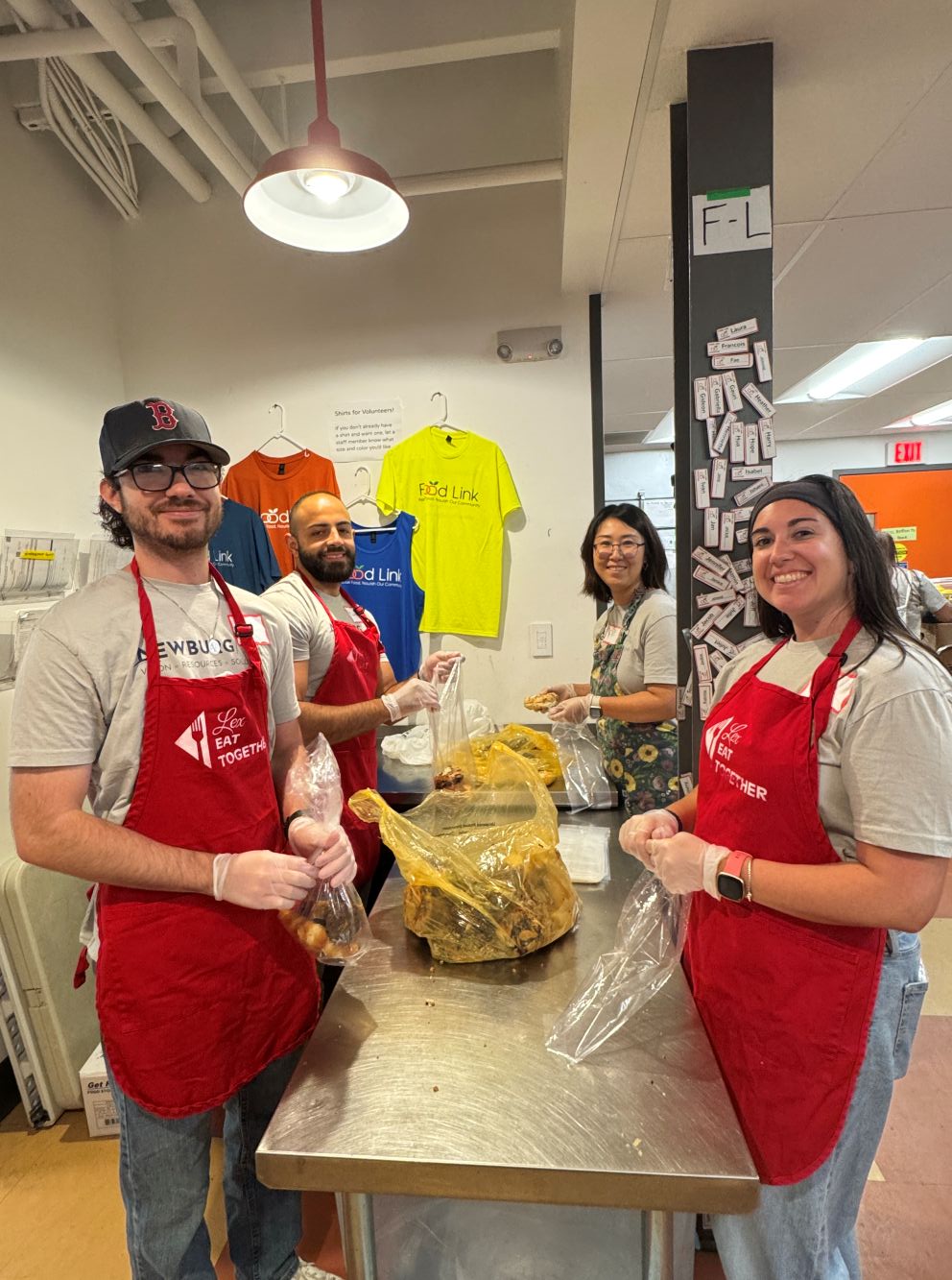 Volunteers in red aprons assembling food packs