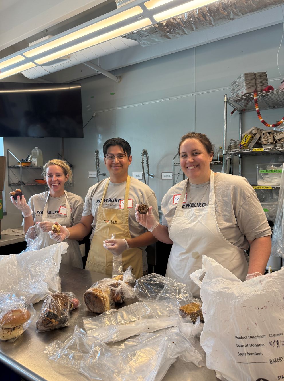 Volunteers smiling while preparing food packs